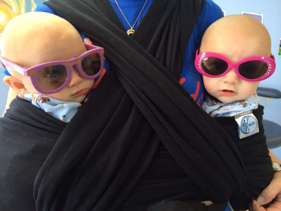 twins in a double sling carrier plagiocephaly