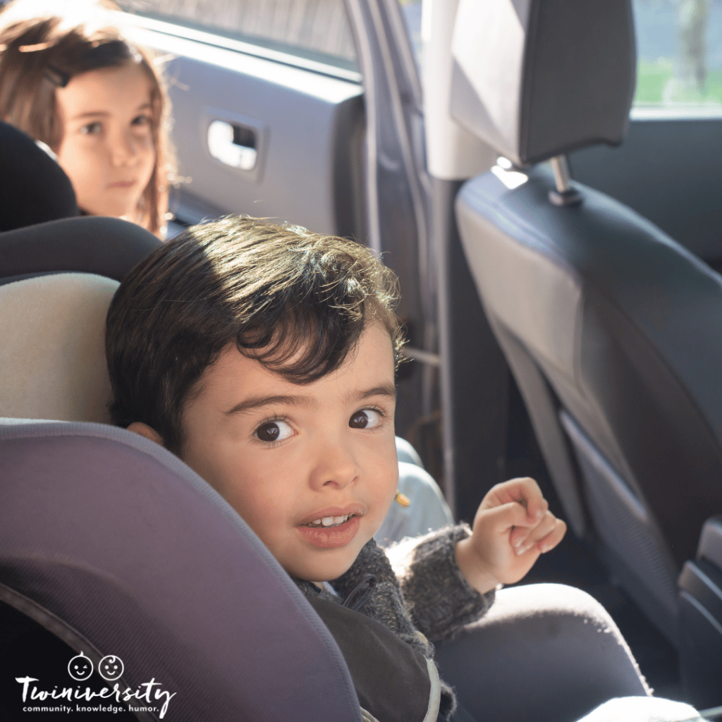 twins in car seats smiling