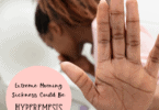 woman vomiting in a toilet and hold her hand up hyperemesis