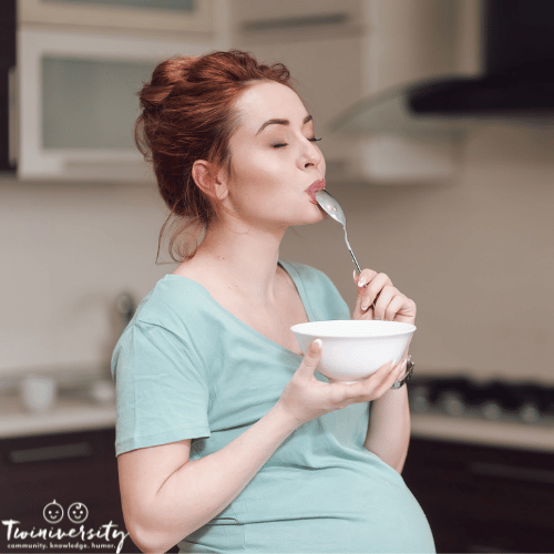 a woman eating food from a bowl when pregnant