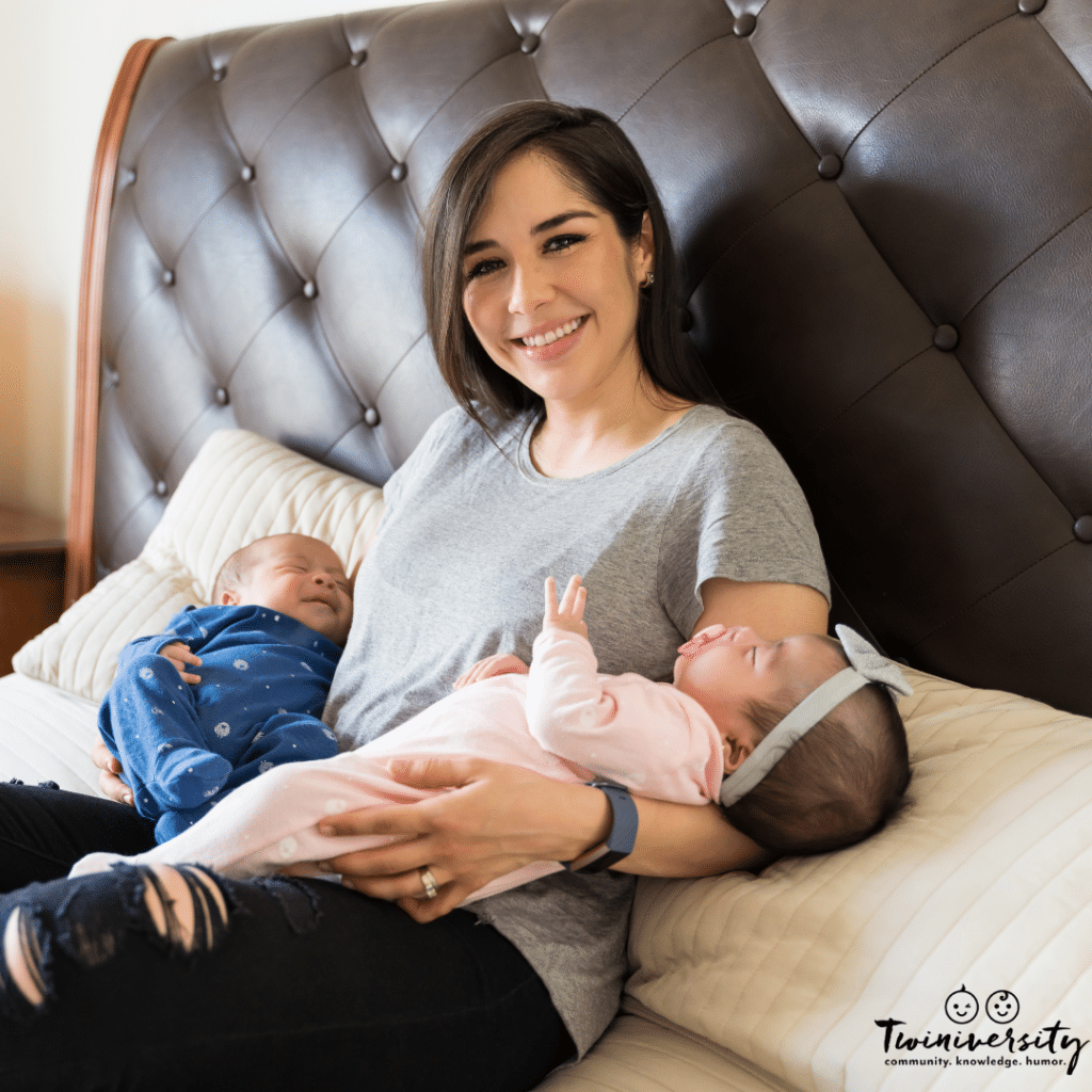 a woman holds twins in bed