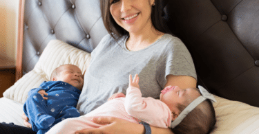 a woman holds twins in bed