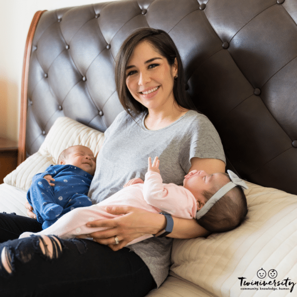 a woman holds twins in bed