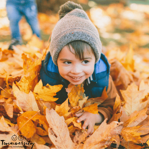 a child jumps into a leaf pile for fall family fun outdoors