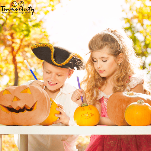 two children paint pumpkins outdoors for fall family fun