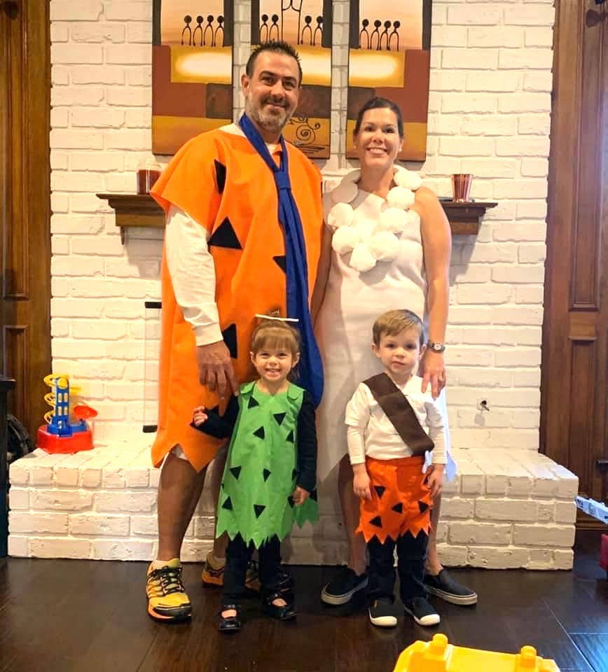 family dressed up like fred wilma pebbles and bam bam from the flintstones