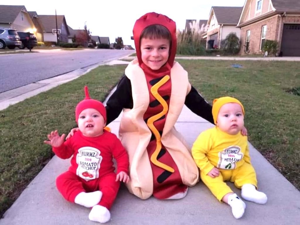 boy and baby twins dressed as hotdog ketchup and mustard