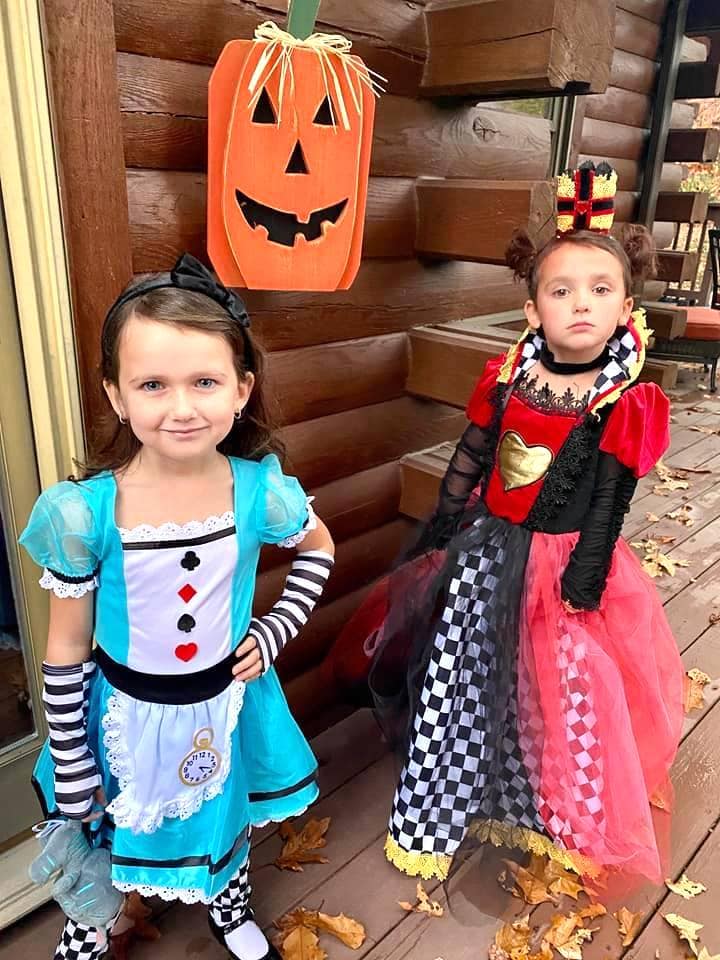 twin girls dressed up as alice and the red queen from alice in wonderland