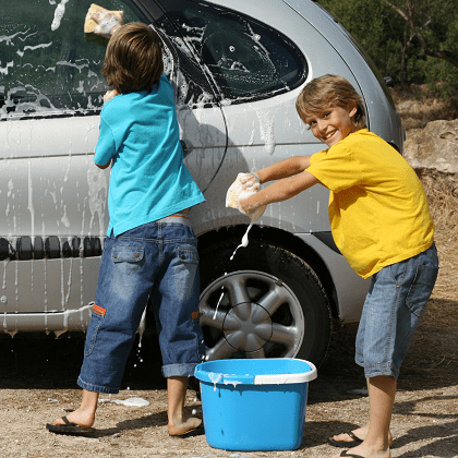 chores for 6-year-olds two boys cleaning the outside of a van with soapy water on big sponges