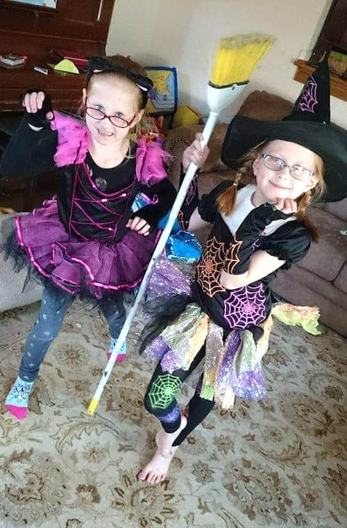 twin girls dressed as a cat and a witch twin girls halloween costumes