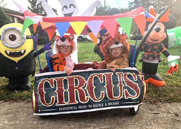 twin girls dressed as lions sitting in a wagon dressed like a circus car twin girls halloween costumes