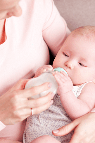 how many bottles do I need  Woman holding and bottle feeding an infant