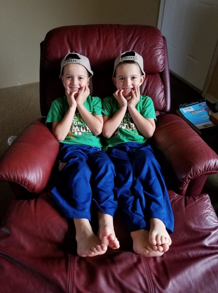 twin boys sitting in a recliner dressing twins alike