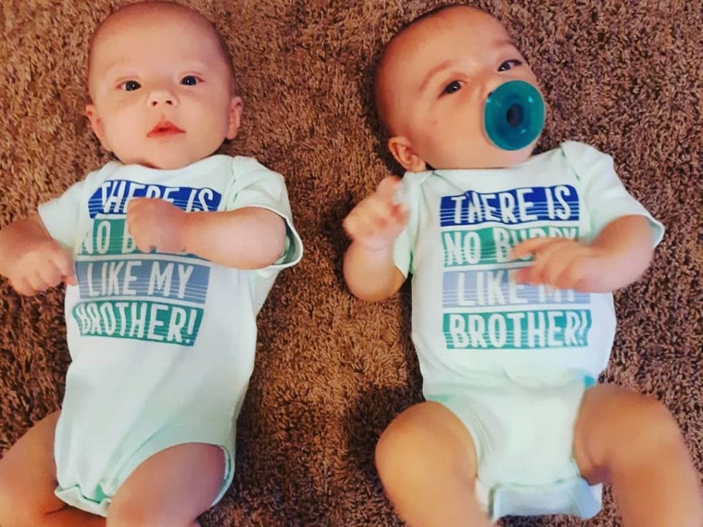 baby twins lying on the rug dressing twins alike