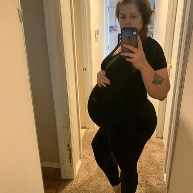 pregnant with twins belly pregnant woman taking a full length selfie in a mirror 