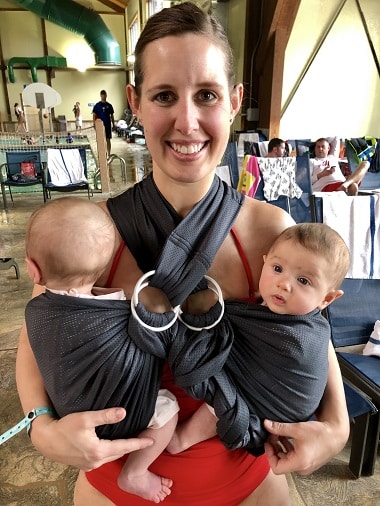 babywearing benefits woman wearing infant twins smiling at the camera