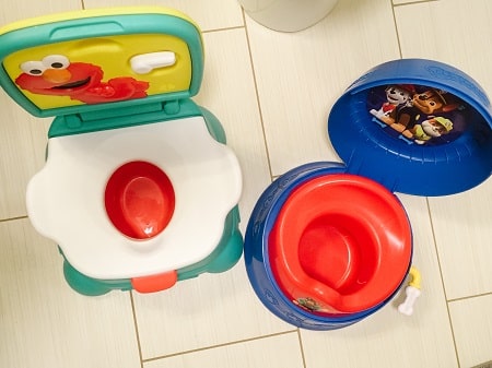 potty training regression two colorful potty seats on a floor, next to one another