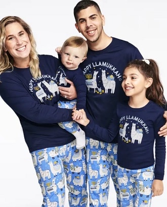 matching christmas pajamas ccouple with a baby and a young girl wearing matching Hanukkah pajamas