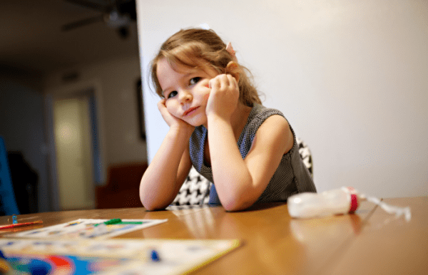 girl sitting at table looking sad stress during covid