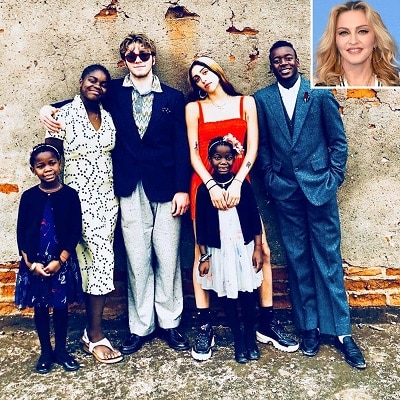 celebrities with twins 6 children of different ages posing together with an inset of Madonna's headshot in the top right corner