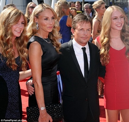 celebrities with twins Michael J Fox with wife and twins smiling for cameras on a red carpet