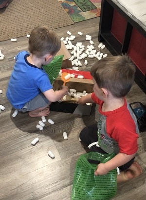 naughty list toddler boys playing with packing peanuts and bags