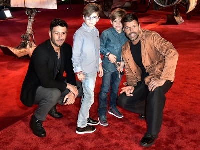 celebrities with twins two men (Martin and Yosef) kneeling down and posing with young twin boys on a red carpet