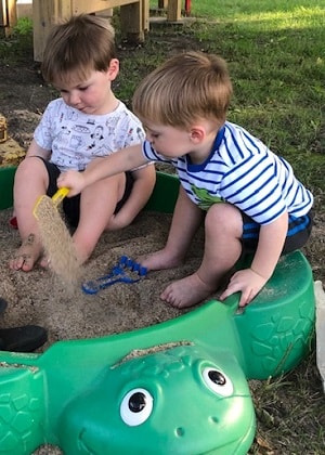 naughty list 2 boys playing with sand in a turtle sand box