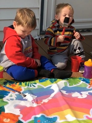 naughty list toddler boys painting and one licking a paint brush