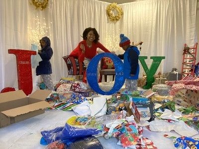 highlights of 2020 a woman smiling with 2 boys in a room with wrapping paper and the word JOY in glitter letters