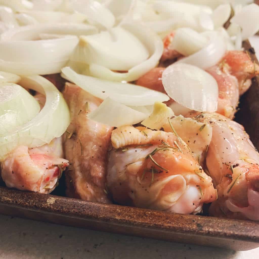 onions on top of raw seasoned chicken wings