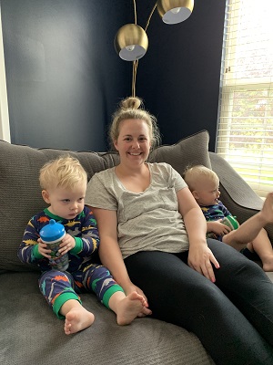 post twins body a woman smiling, sitting on a couch with 2 young children