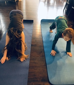 indoor physical activities 2 young kids doing yoga on mats