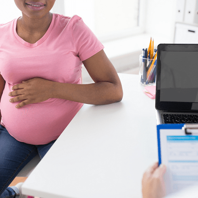 placenta previa a pregnant woman holding her belly, sitting in a chair