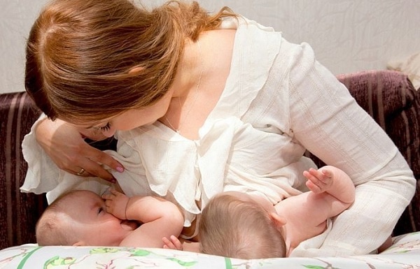 breastfeeding twins articles a new mom breastfeeding two infants on a breastfeeding pillow