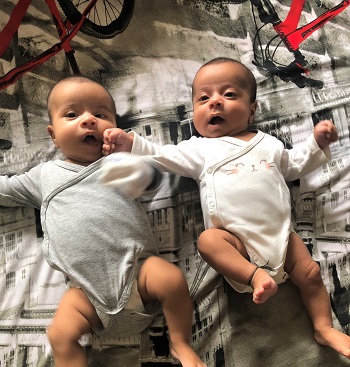 newborn twins laying on their backs on a blanket