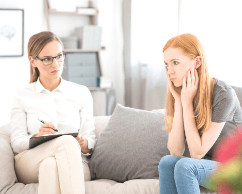 birth trauma a young woman speaking to a therapist on a couch