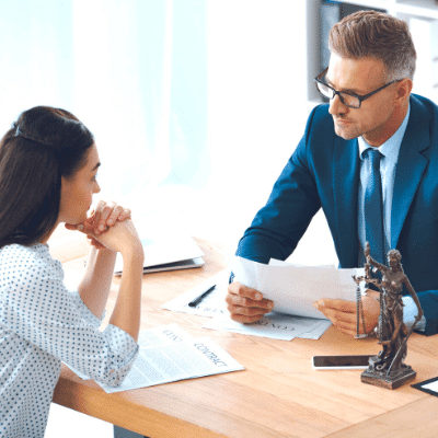 surviving divorce a woman meeting with a lawyer and going over papers together