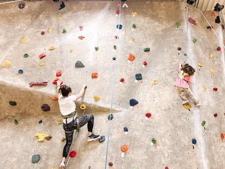 destructive kids a woman and child climbing a rock wall