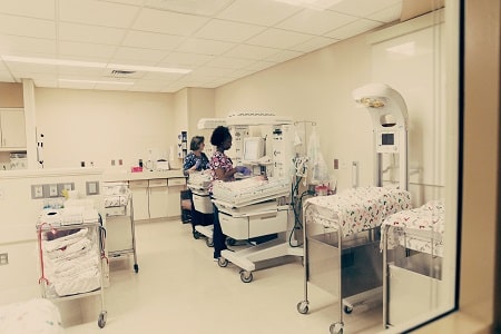 birth trauma a nursery with 2 nurses attending to infants and medical equipment