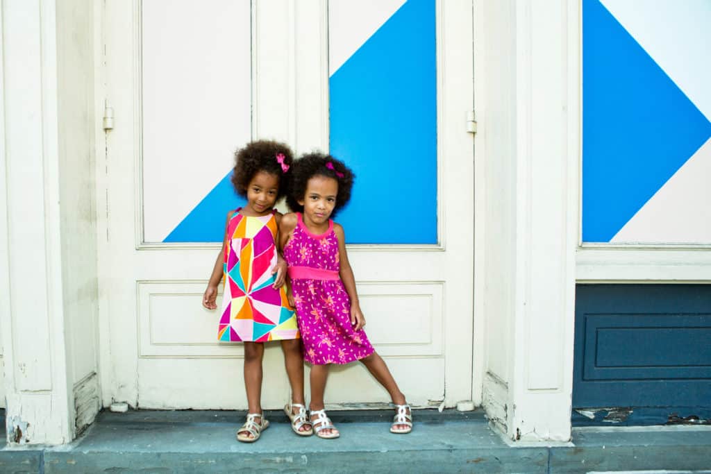 twin girls standing in a doorway