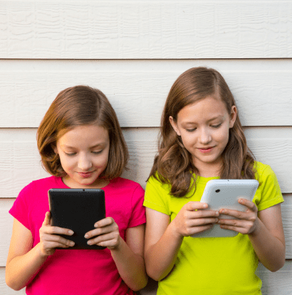 twin girls playing on tablets together