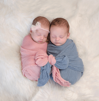 newborn boy/girl twins sleeping and wrapped in blankets together  the biology of twins 