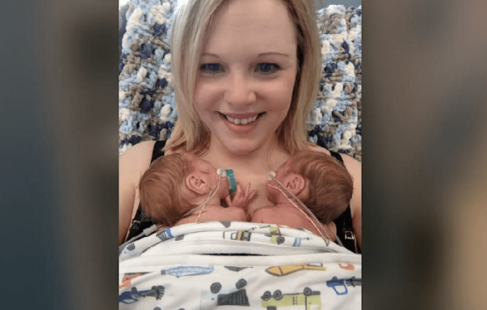 twins born in different months being held by their mother in the NICU