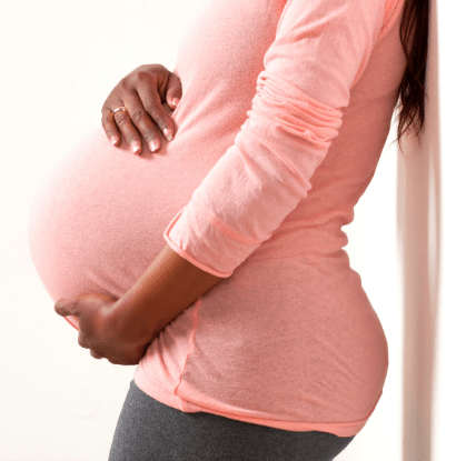 di di twin pregnancy woman with pregnant belly leaning against a wall