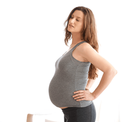 pregnant woman with hands on her hips to stretch out pregnancy rib pain