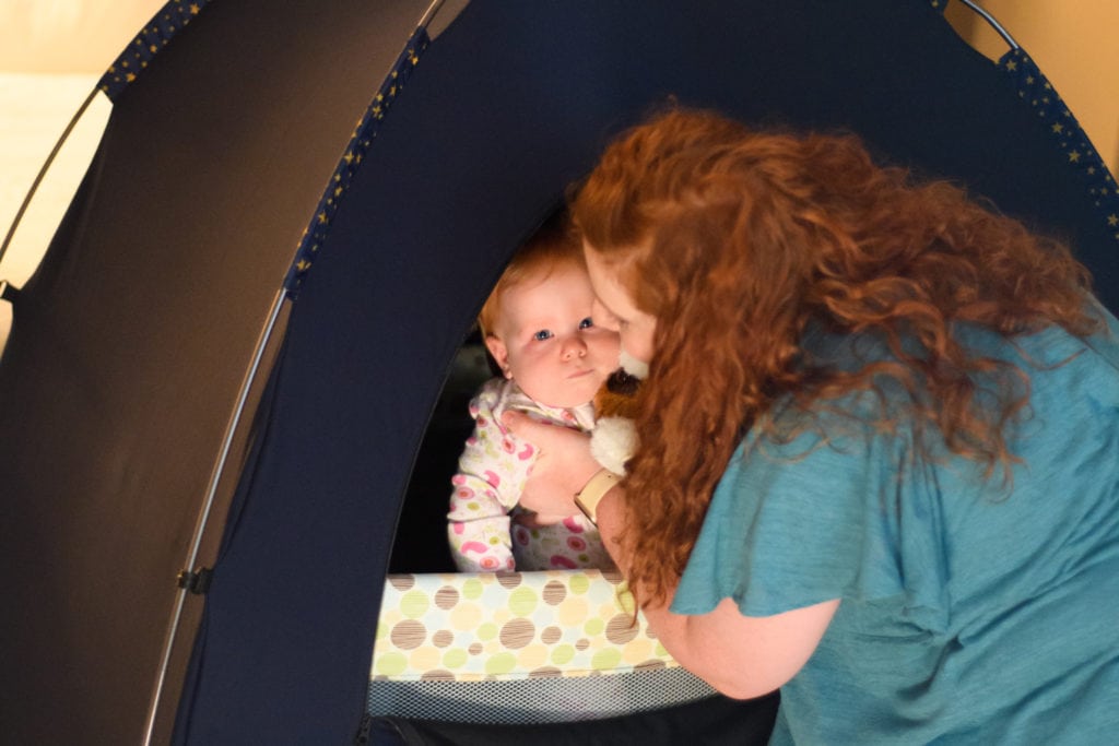 baby and mom in a travel crib with a slumberpod