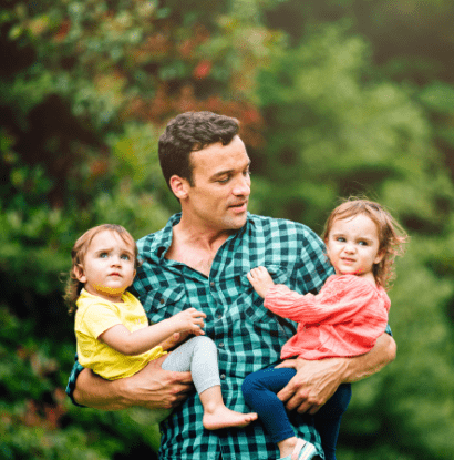 man holding twins on hips