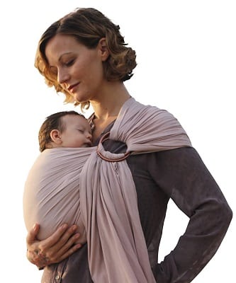 a woman cradling a sleeping newborn in a ring sling carrier