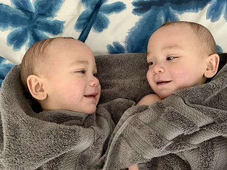 twin boys wrapped in gray towels